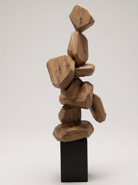 Sculpture abstraite en bois naturel composée de formes organiques sur un socle noir