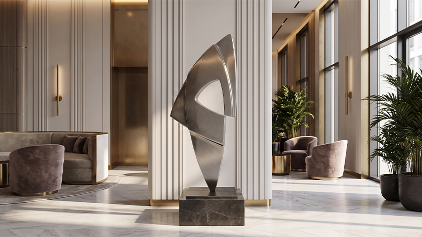 Sculpture abstraite en inox brossé installée sur un socle dans le hall contemporain d’un hôtel